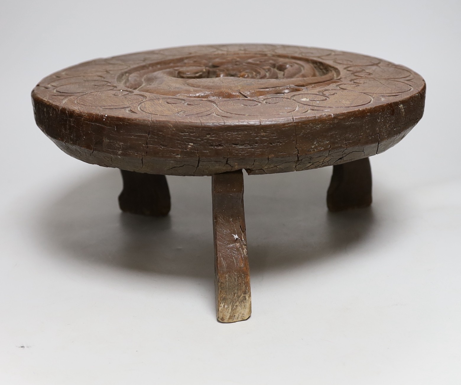 A South East Asian circular carved wooden stool, 36cms diameter